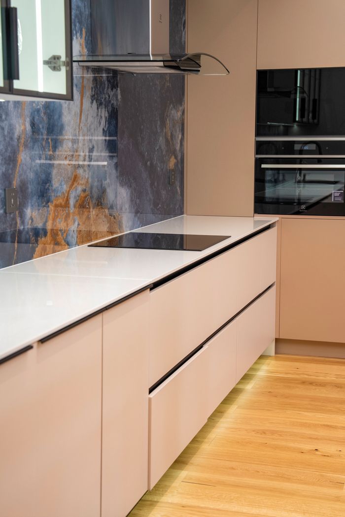 Sleek modern kitchen design featuring minimalist cabinets and marble backsplash.